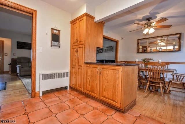 kitchen featuring ceiling fan, radiator heating unit, and kitchen peninsula