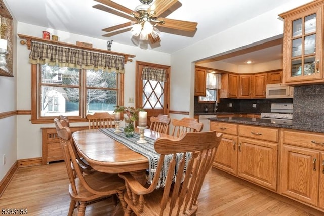 dining area featuring light wood-type flooring, a healthy amount of sunlight, and sink