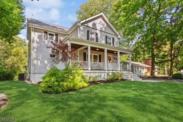 view of front of property with a front yard, covered porch, and central AC unit