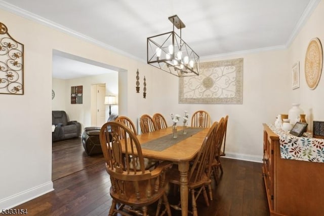 dining area featuring dark wood-type flooring, ornamental molding, and a chandelier