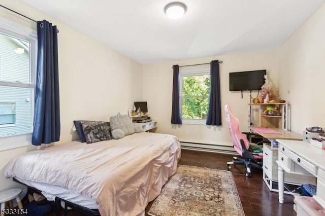 bedroom featuring a baseboard heating unit and dark hardwood / wood-style flooring