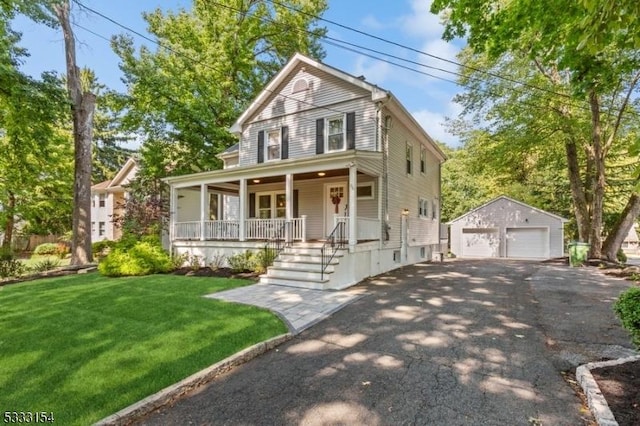 view of front of property with an outbuilding, a front yard, covered porch, and a garage