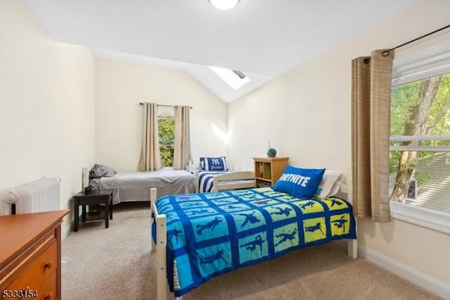 carpeted bedroom with vaulted ceiling with skylight and radiator heating unit