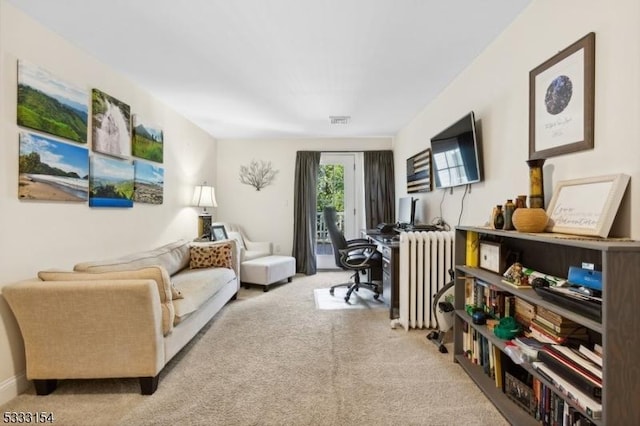 sitting room featuring radiator and light colored carpet