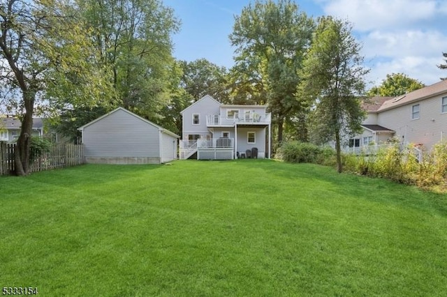 back of house with a lawn, a balcony, and a wooden deck