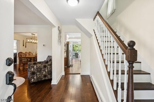 stairway with wood-type flooring and a chandelier