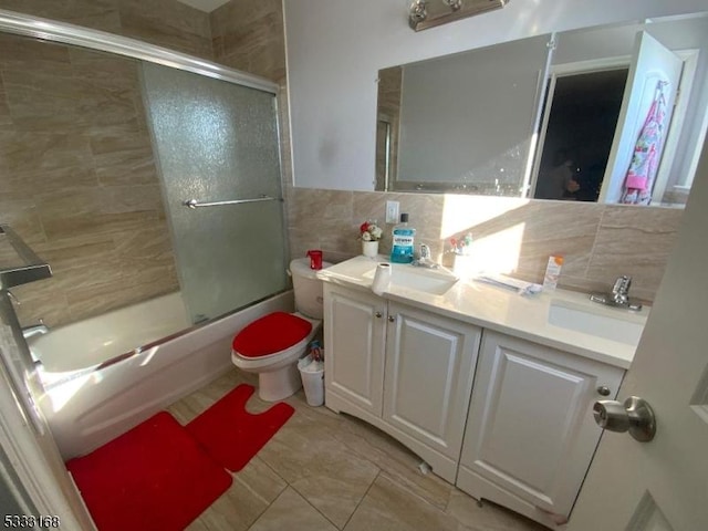 full bathroom with enclosed tub / shower combo, tile walls, vanity, and toilet