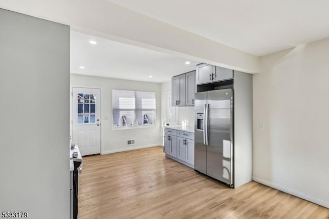 kitchen featuring gray cabinets, stainless steel appliances, and light hardwood / wood-style flooring