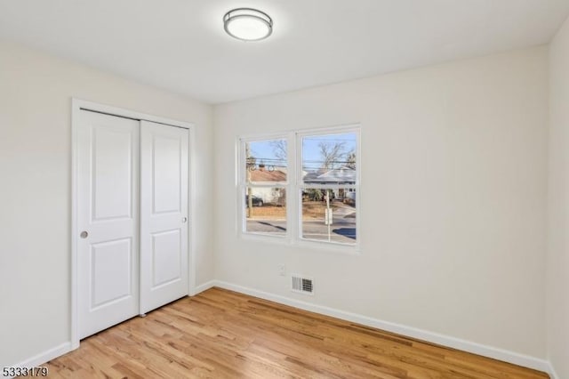 unfurnished bedroom with a closet and light hardwood / wood-style flooring