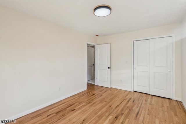 unfurnished bedroom featuring a closet and light hardwood / wood-style floors