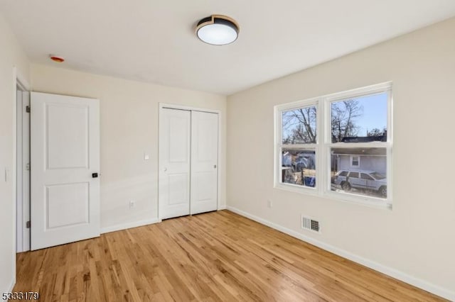 unfurnished bedroom with light hardwood / wood-style floors and a closet