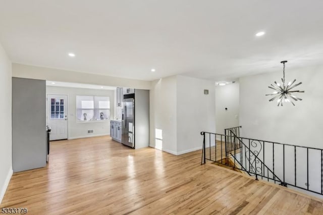 spare room featuring light hardwood / wood-style flooring and a notable chandelier