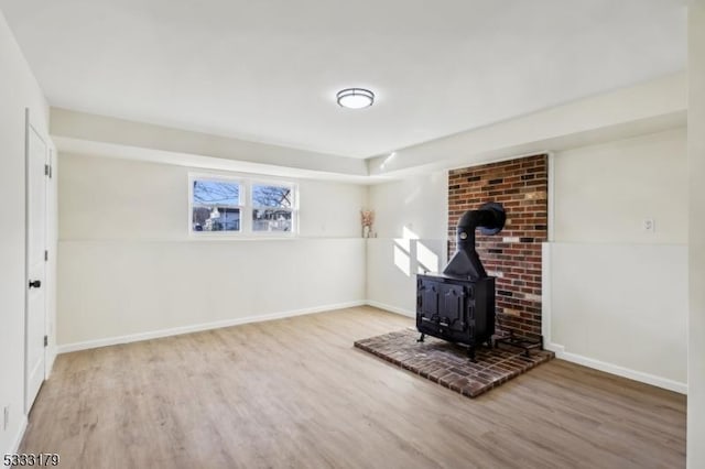 unfurnished living room featuring a wood stove and wood-type flooring