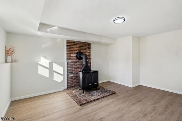 basement featuring a wood stove and hardwood / wood-style floors