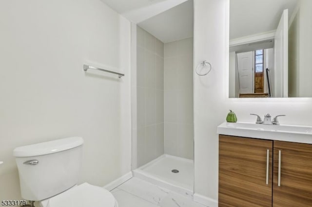 bathroom with toilet, vanity, and a tile shower