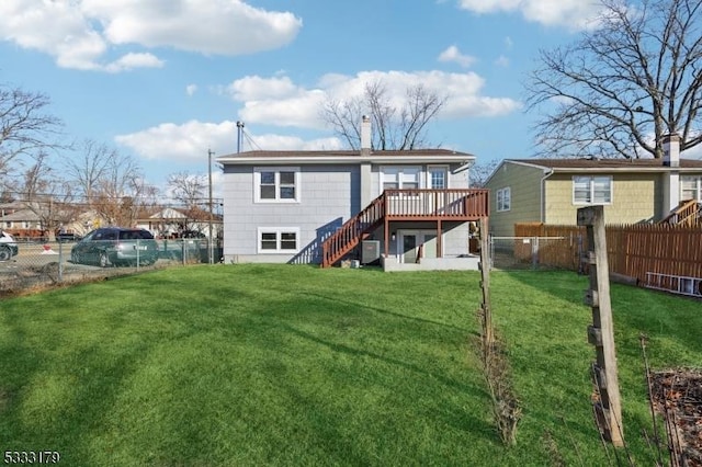 rear view of house with a deck and a lawn