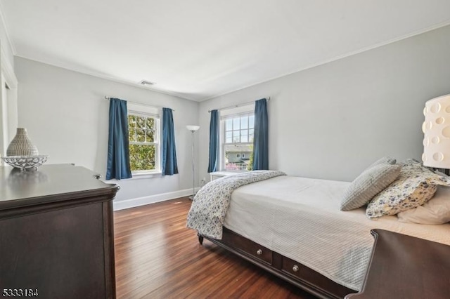 bedroom featuring baseboards, wood finished floors, and visible vents