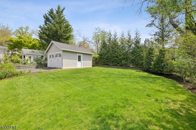 view of yard featuring a garage and an outdoor structure