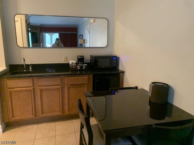 kitchen with sink, light tile patterned floors, and black appliances