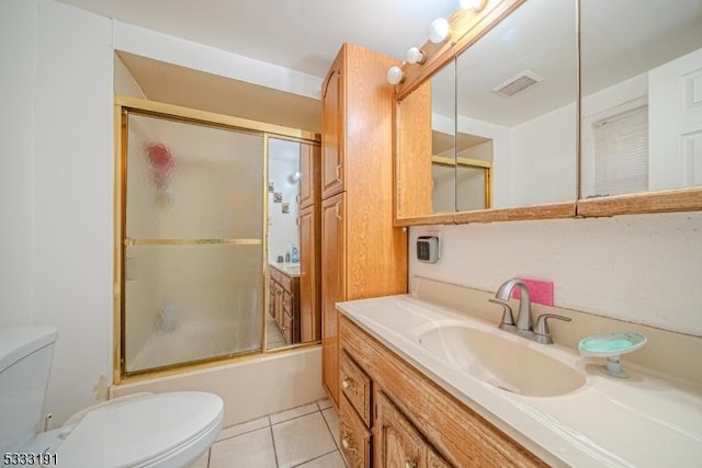 full bathroom featuring tile patterned floors, bath / shower combo with glass door, toilet, and vanity