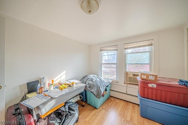 office featuring cooling unit, a baseboard heating unit, and light hardwood / wood-style flooring