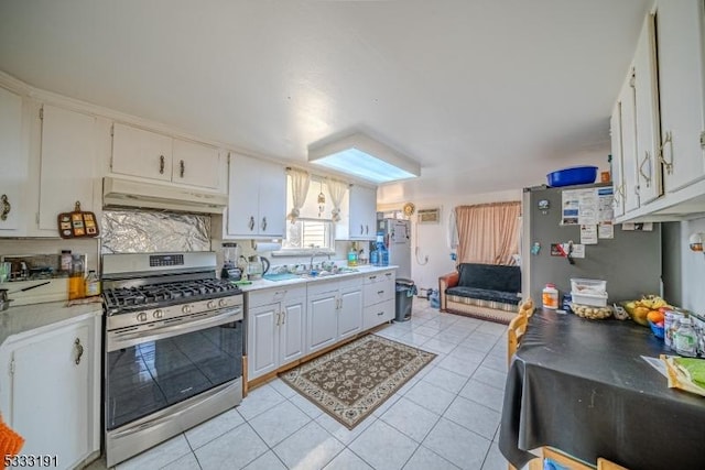 kitchen with tasteful backsplash, sink, light tile patterned flooring, stainless steel appliances, and white cabinets