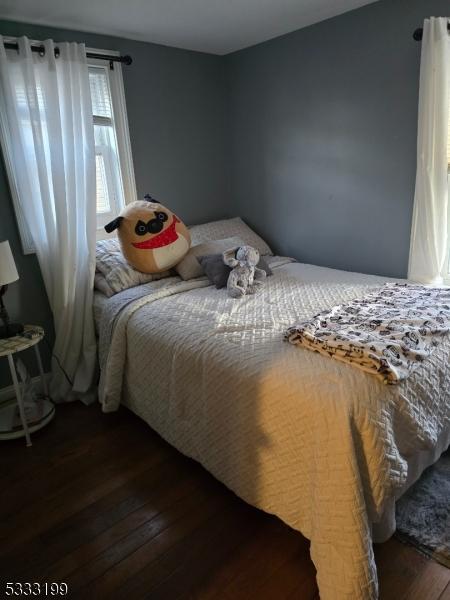 bedroom with dark hardwood / wood-style flooring