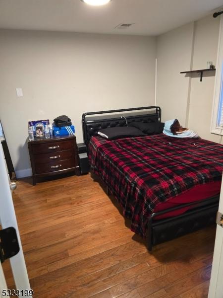 bedroom with hardwood / wood-style flooring