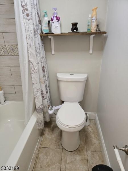 bathroom with toilet and shower / bath combo