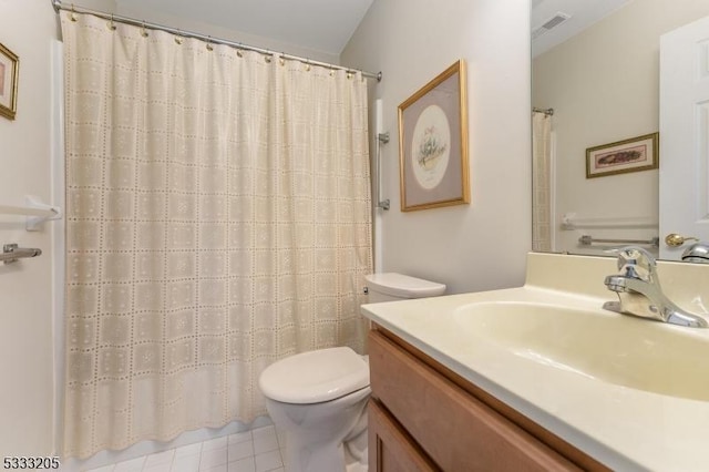 bathroom with toilet, vanity, and tile patterned floors