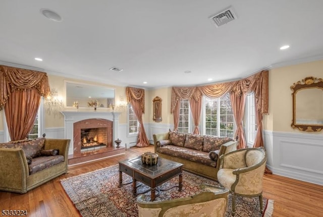 living room with light hardwood / wood-style flooring and ornamental molding