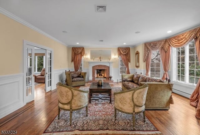 living room with light wood-type flooring, plenty of natural light, and a baseboard radiator