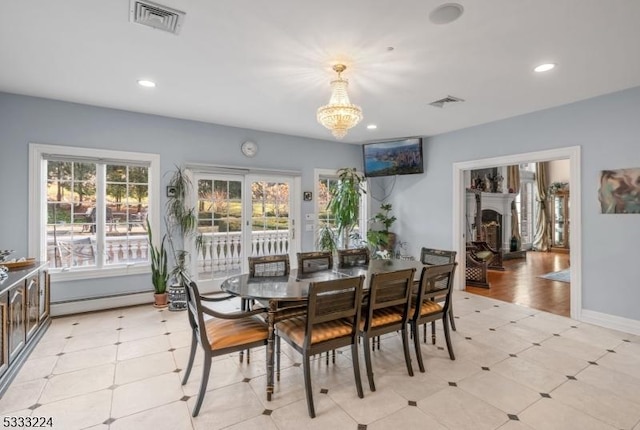 dining space featuring a baseboard radiator and an inviting chandelier