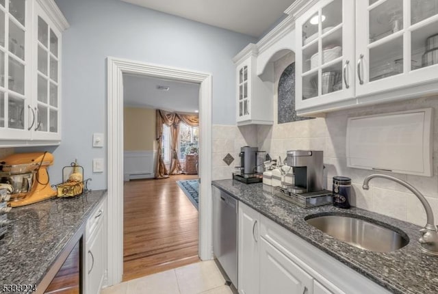 kitchen featuring sink, white cabinetry, stainless steel dishwasher, and light tile patterned flooring