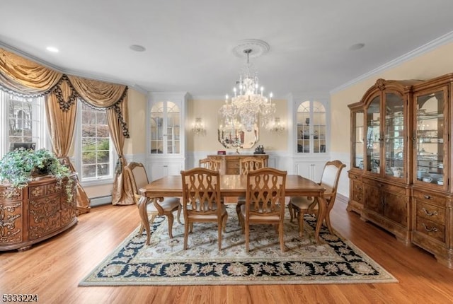 dining room featuring baseboard heating, an inviting chandelier, crown molding, and light hardwood / wood-style floors