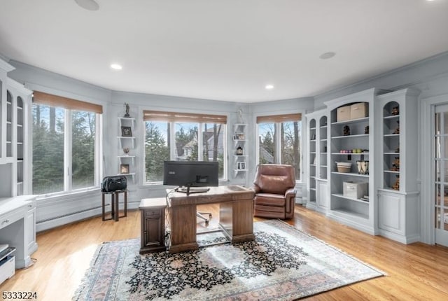 office area featuring a baseboard heating unit and light hardwood / wood-style flooring