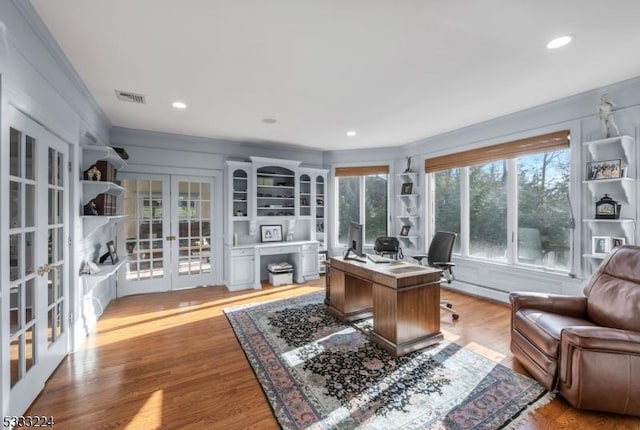 office area featuring baseboard heating, crown molding, light hardwood / wood-style floors, and french doors