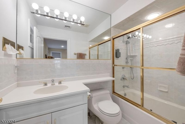 full bathroom featuring toilet, backsplash, bath / shower combo with glass door, tile walls, and vanity