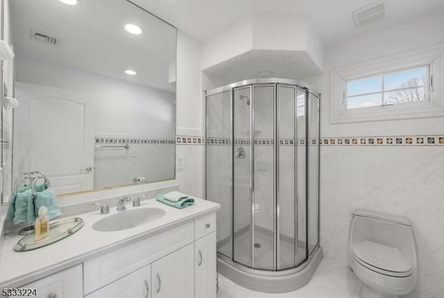 bathroom featuring tile walls, toilet, vanity, and an enclosed shower