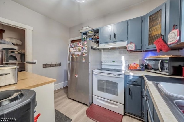 kitchen with tasteful backsplash, stainless steel refrigerator, white range with electric cooktop, blue cabinets, and wood counters