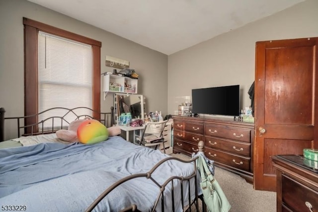 carpeted bedroom with lofted ceiling