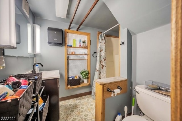 bathroom featuring toilet, vanity, and a shower with shower curtain