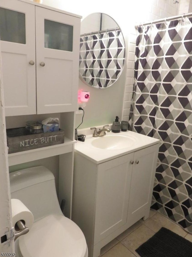 bathroom with toilet, vanity, tile patterned flooring, and a shower with curtain