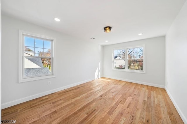 spare room with a wealth of natural light and light hardwood / wood-style flooring