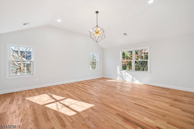 unfurnished living room with light wood-type flooring, vaulted ceiling, and a chandelier