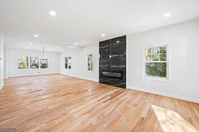 unfurnished living room featuring light hardwood / wood-style floors and a premium fireplace