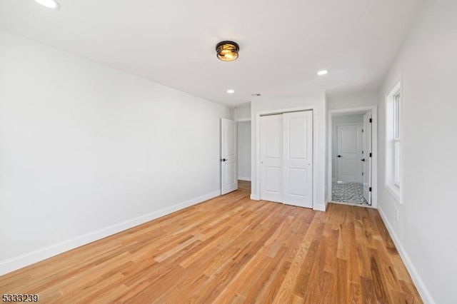 unfurnished bedroom with a closet and light hardwood / wood-style flooring