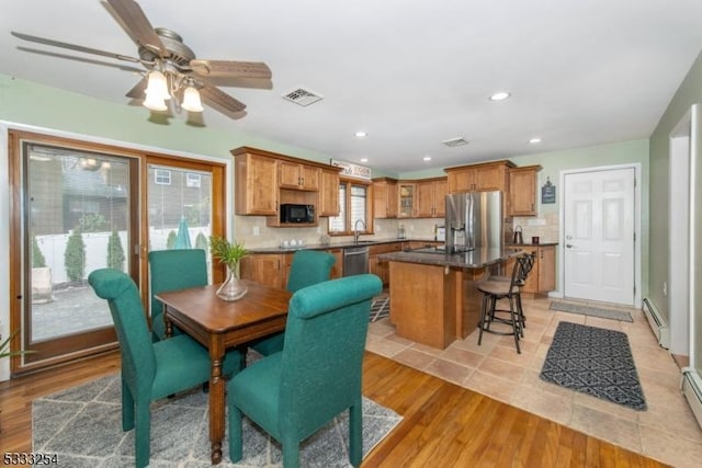 dining space featuring sink, a baseboard radiator, and light hardwood / wood-style floors