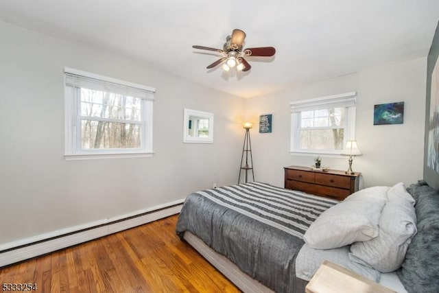 bedroom featuring baseboard heating, ceiling fan, and hardwood / wood-style flooring