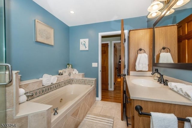 bathroom with vanity, tile patterned flooring, and tiled bath